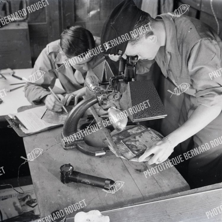 F677 À l'aide d'un stéréoscope un des officiers du service photo examine les résultats d'un bombardement. MARAUDERS B26 FRANÇAIS 1944